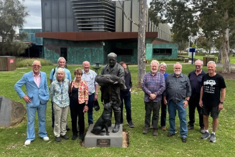 The class of 1975 standing with statue at Werribee campus.